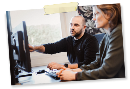 Support-Mitarbeiter erklärt einer Kollegin Inhalte auf dem Monitor
