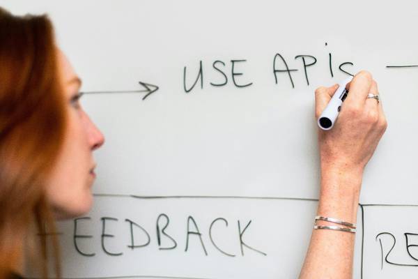 Frau am Whiteboard, die schreibt Use APIs